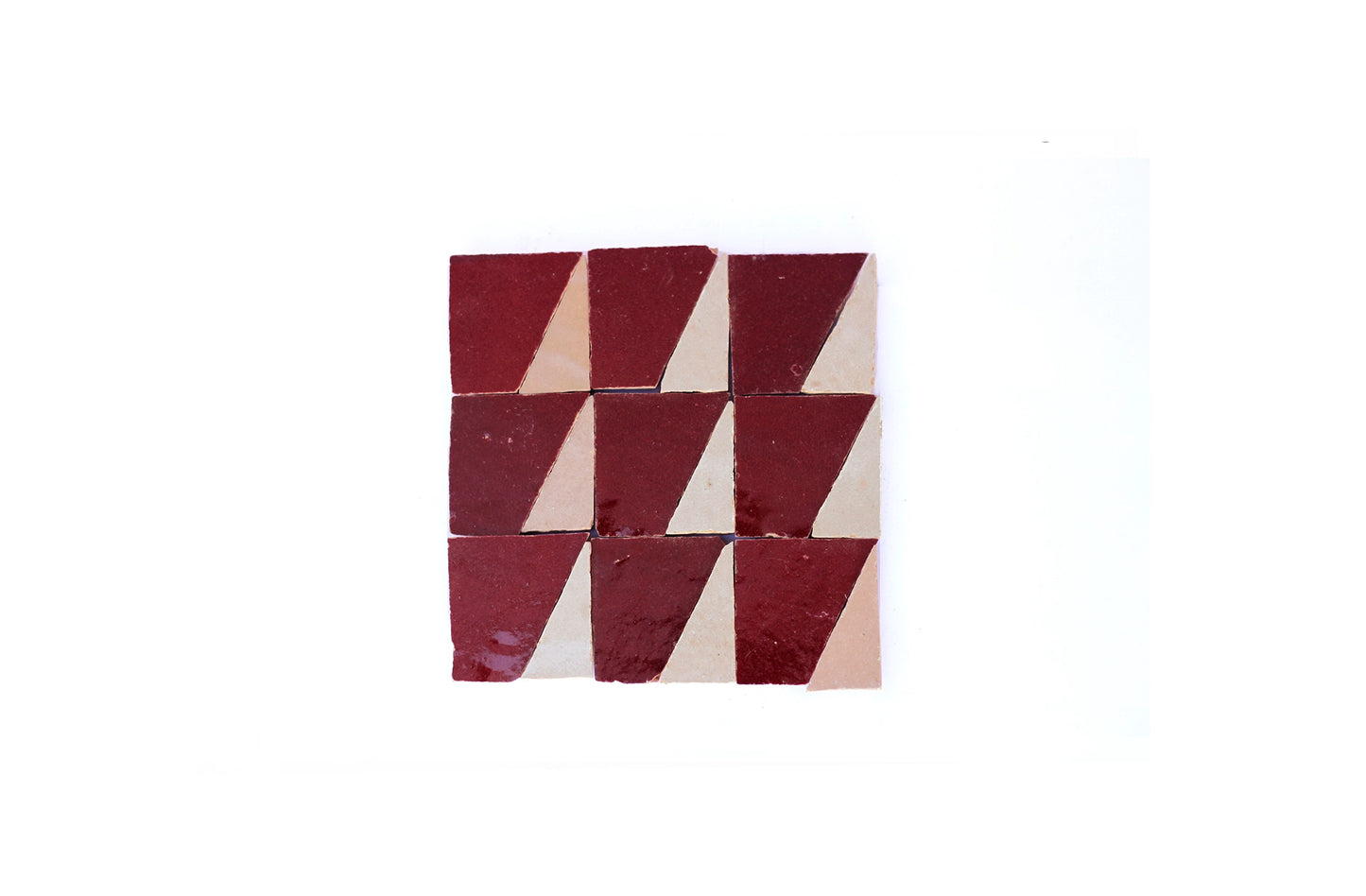Handmade Moroccan Zellige tile in triangle geometric mosaic pattern in a deep burgundy red glaze and cream colored unique zellige tile