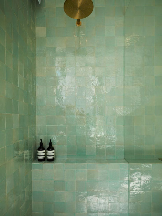 Handmade mint green Moroccan Zellige tiles in 4x4 inches 2x2 inches 10x10 cm and 5x5 cm sizes with glossy finish used in a modern shower with brass rain shower head and built in bench
