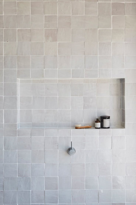 Handmade white Moroccan Zellige tiles in 4x4 inches 2x2 inches 10x10 cm and 5x5 cm with built in shower niche and matte silver faucet in minimalist bathroom design
