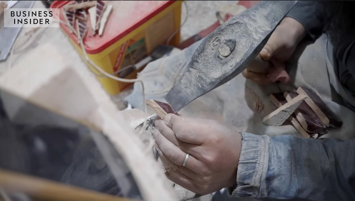 Artisan hand-cutting a Moroccan Zellige tile using a traditional chisel tool, House of Anouar