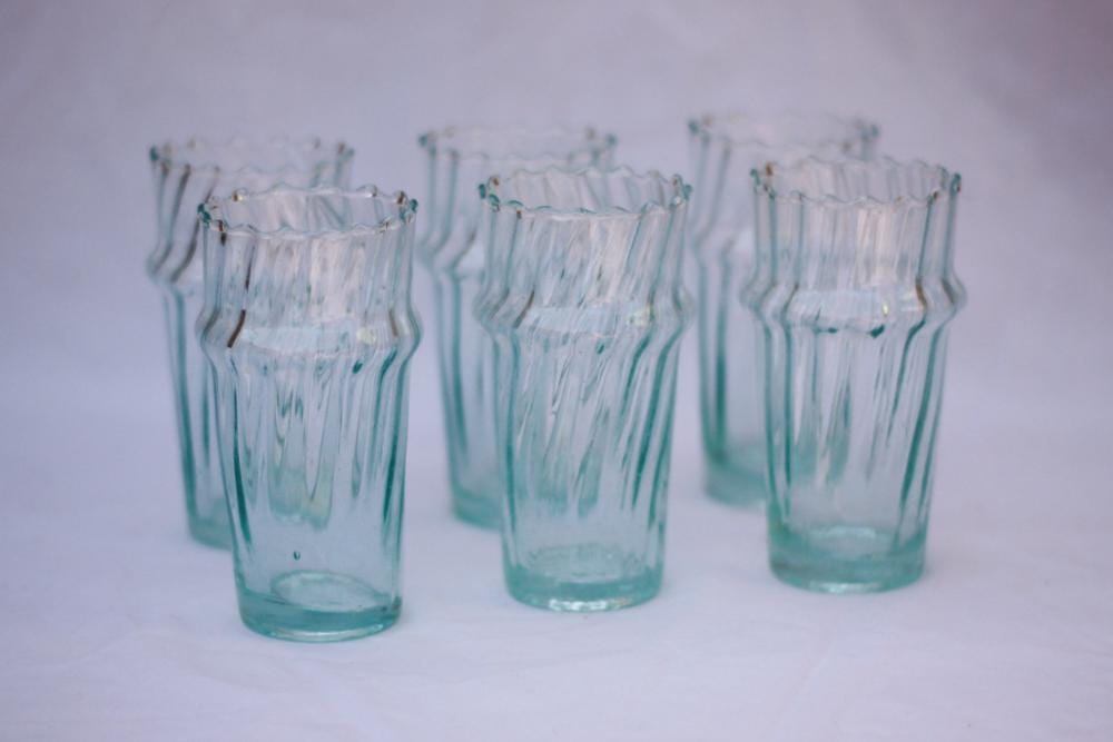 Clear fluted Moroccan Beldi glasses grouped on white fabric, House of Anouar