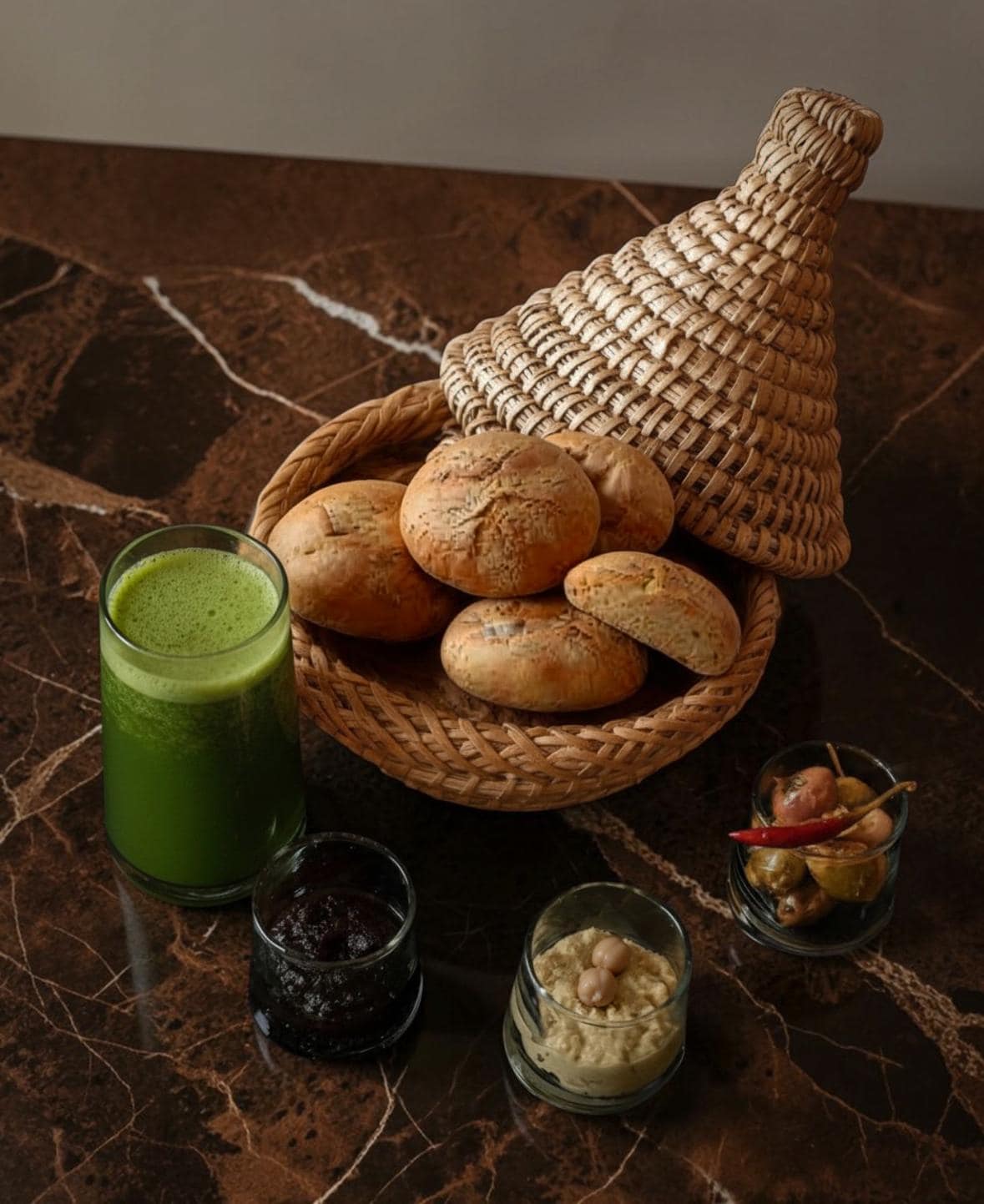 Moroccan woven basket with bread and a green Beldi glass, House of Anouar