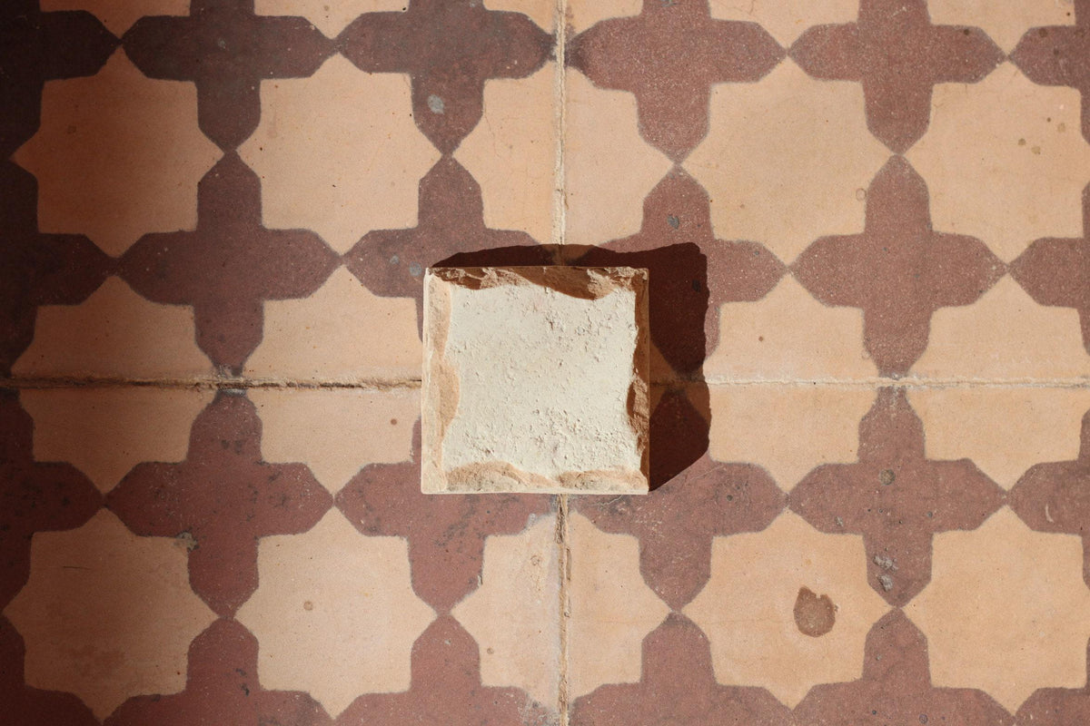Natural unglazed zellige sample on a patterned floor, House of Anouar