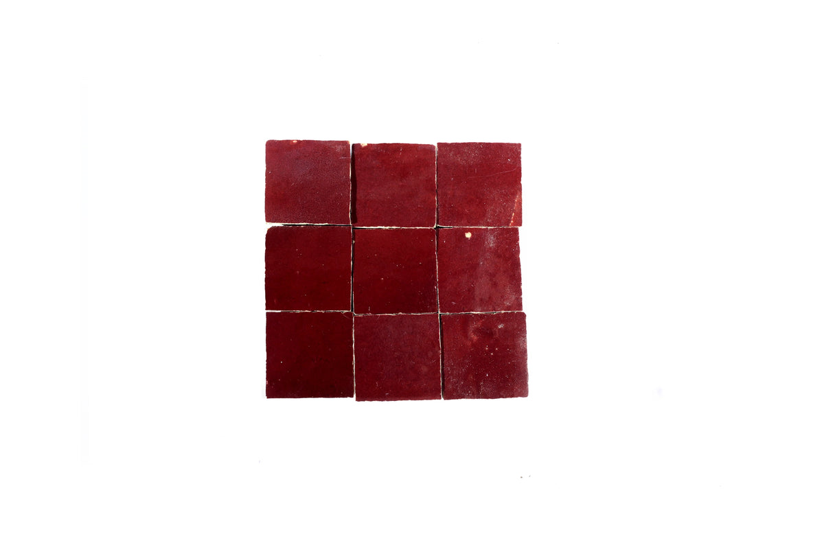 Nine burgundy red handmade Moroccan Zellige tiles arranged in a square grid on a white background, House of Anouar