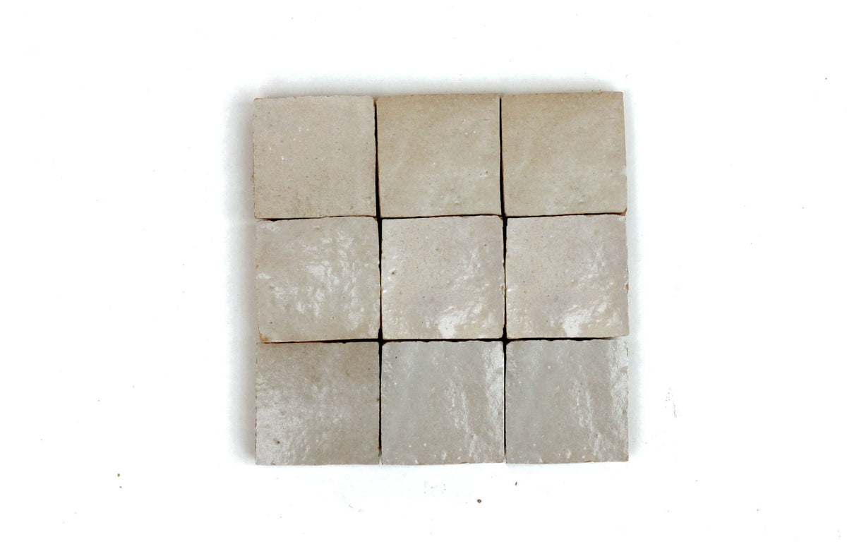 Nine square handmade Moroccan Zellige tiles in a neutral beige color arranged in a grid, House of Anouar