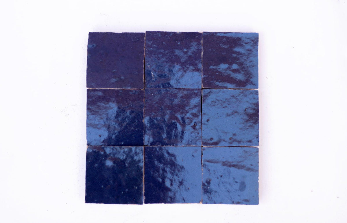 Nine square handmade navy blue Moroccan Zellige tiles arranged in a grid on a white background, House of Anouar