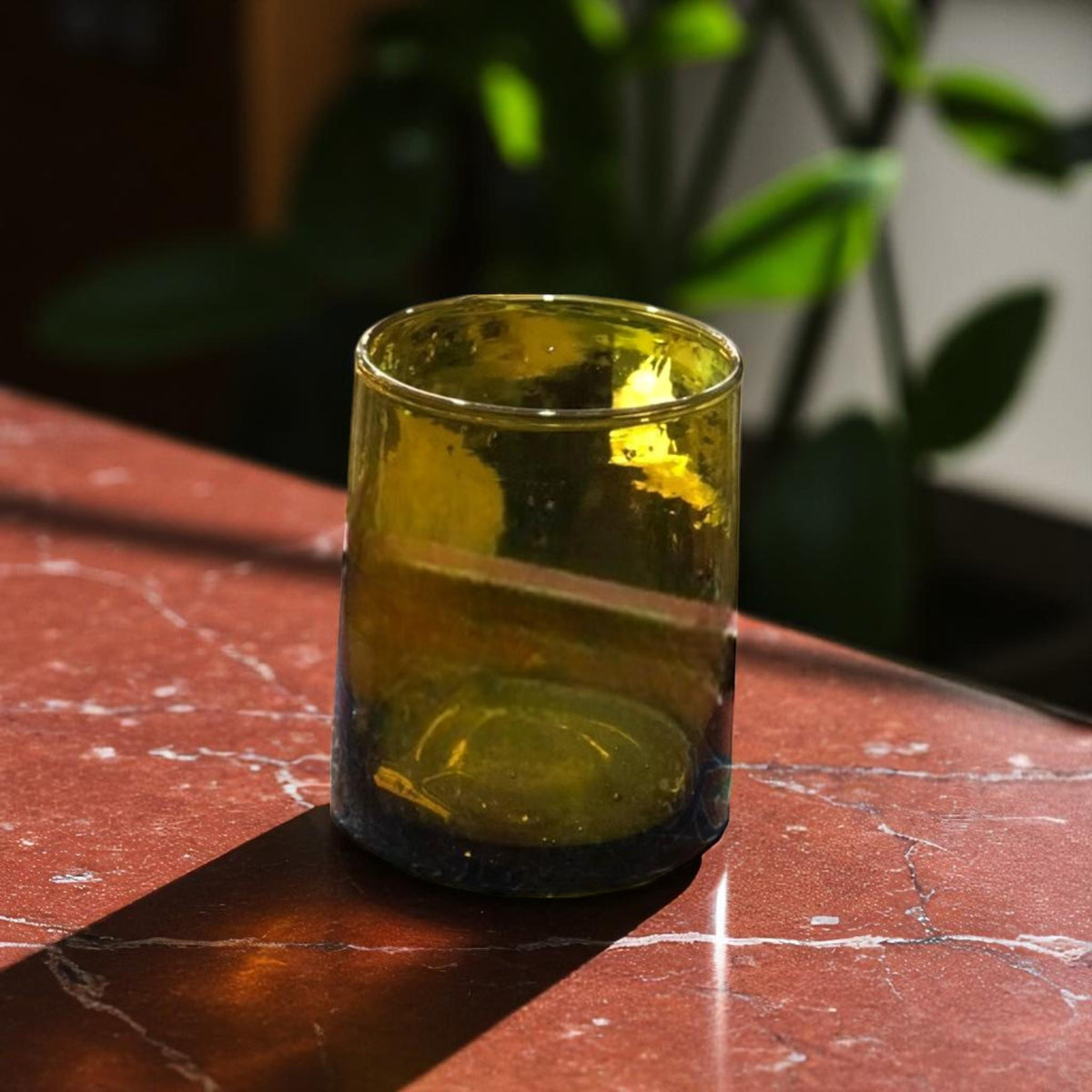 Olive green handcrafted recycled Moroccan Beldi glass on a marble surface, House of Anouar