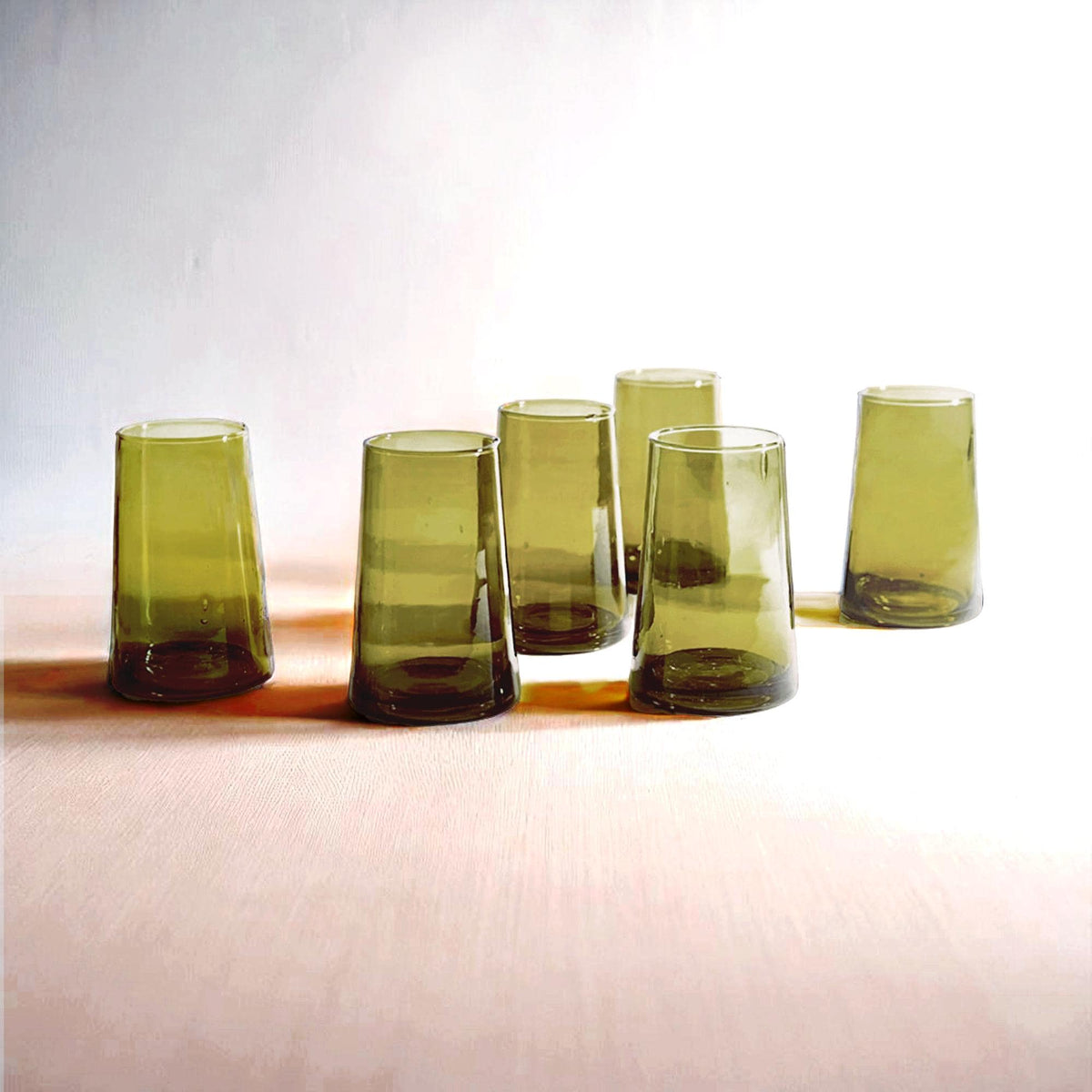 Six large olive green cone-shaped Moroccan Beldi drinking glasses on a light surface, House of Anouar