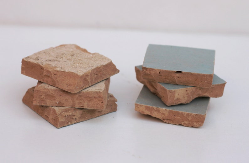 Two small stacks of handmade light blue and terracotta Moroccan Zellige tiles by House of Anouar